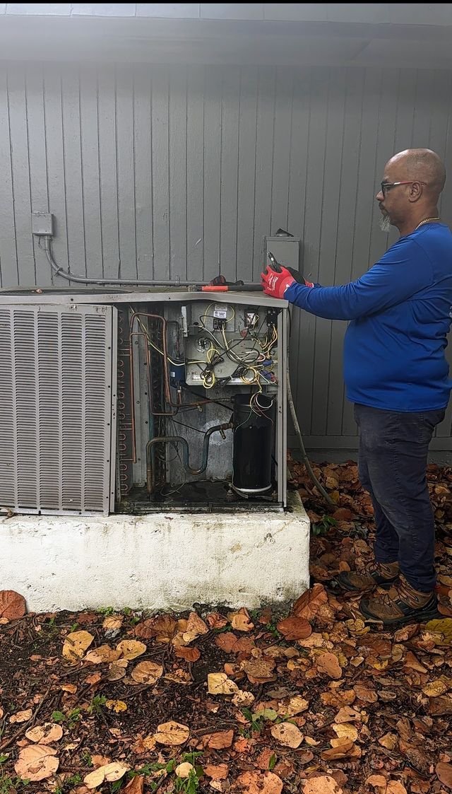 Technician servicing an outdoor condenser unit