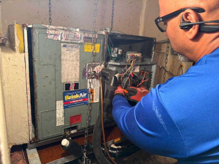 Technician repairing an indoor air handler unit