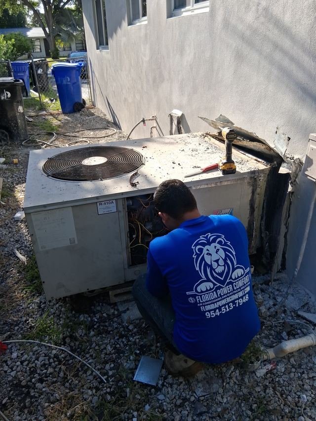 Technician servicing a rooftop package unit