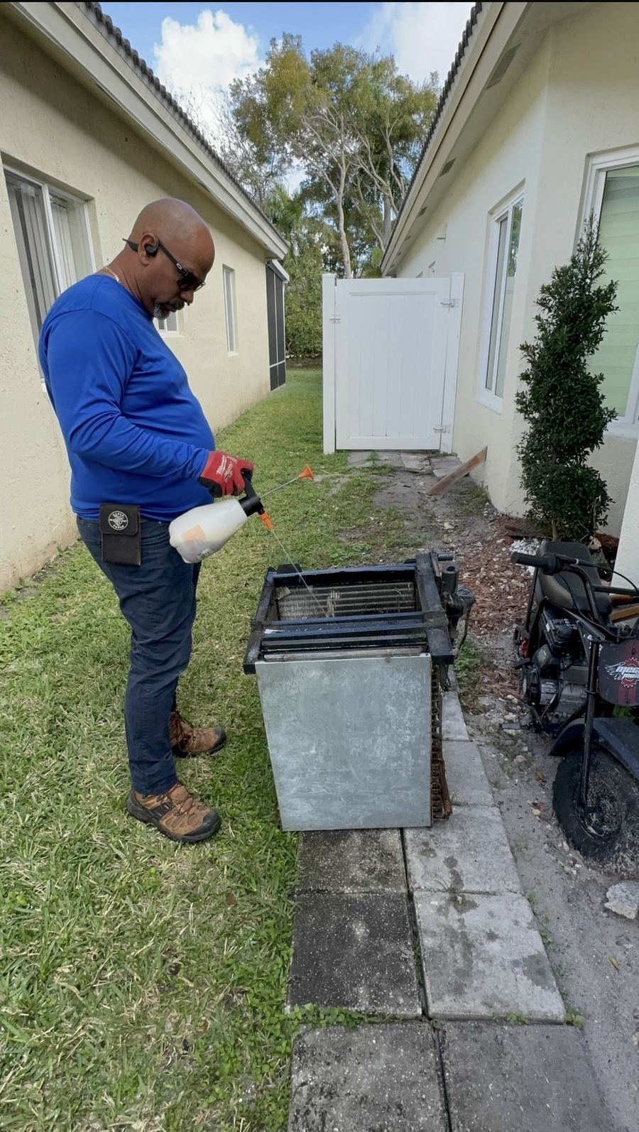 Technician servicing a furnace and air handler in a garage
