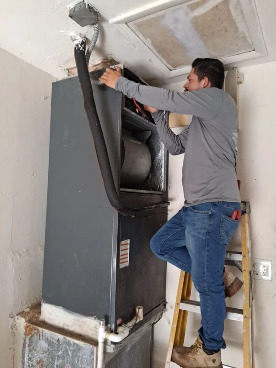 Technician working on an attic air handler