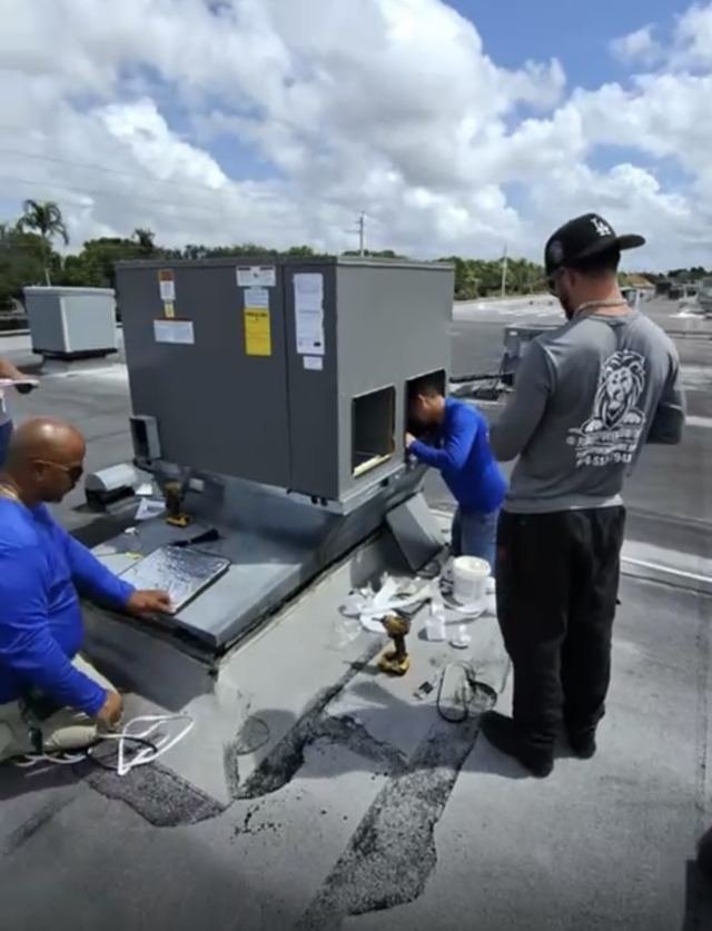 Crew installing a rooftop package unit