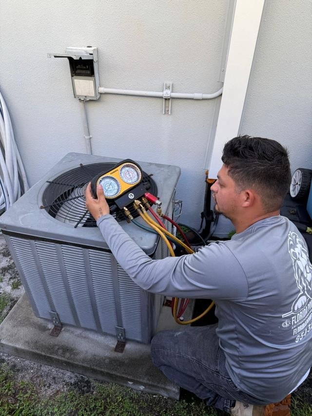 Technician taking gauge readings on a condenser