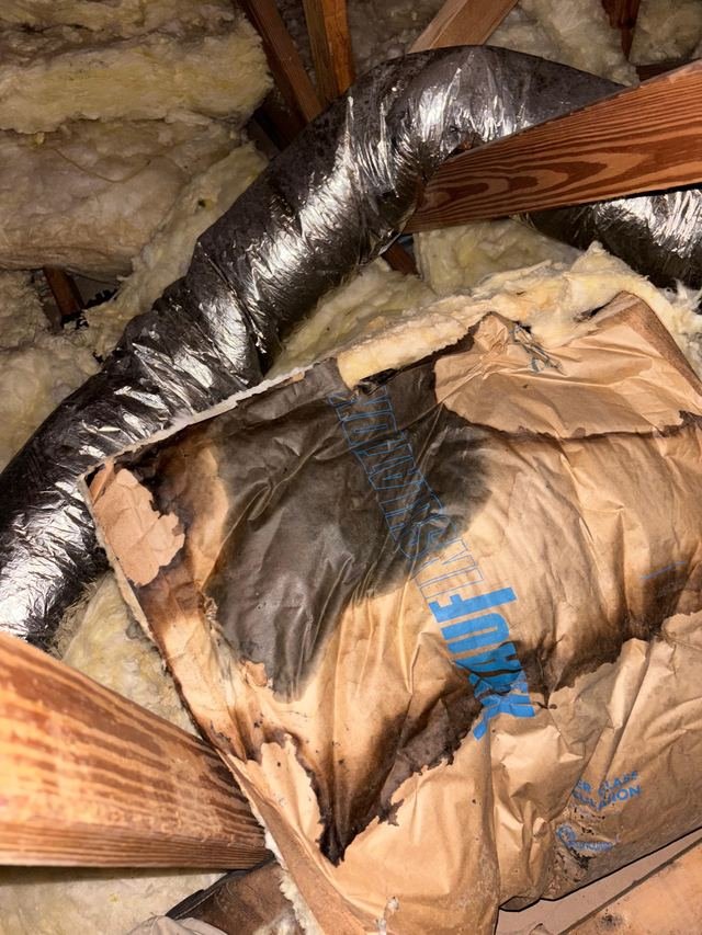 Deteriorated attic ductwork and insulation before repair