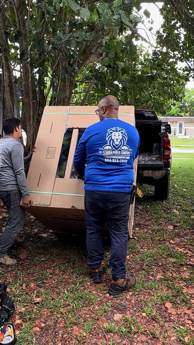 Technicians delivering a new AC unit to a job site