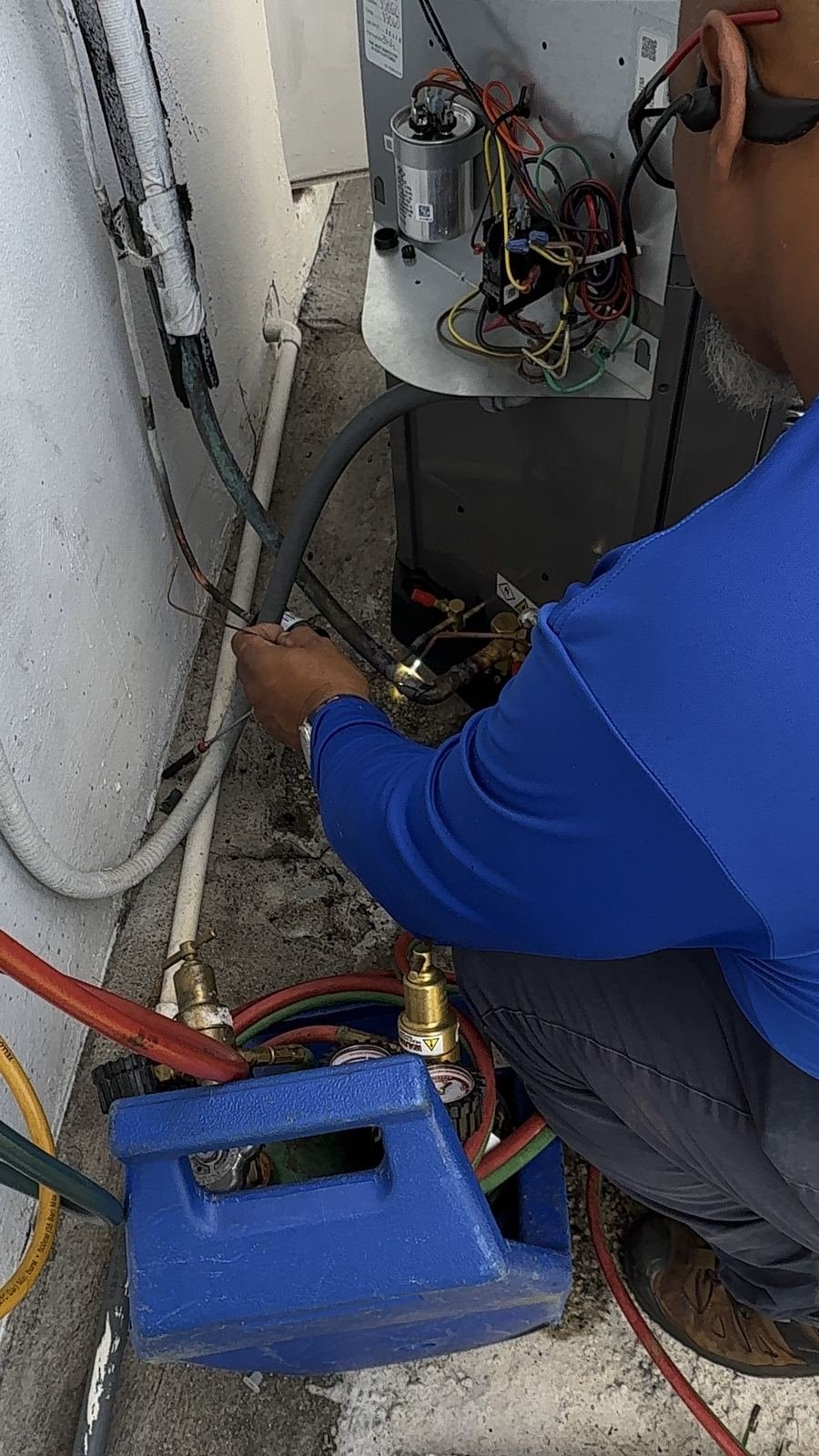 Technician cleaning an AC condenser coil
