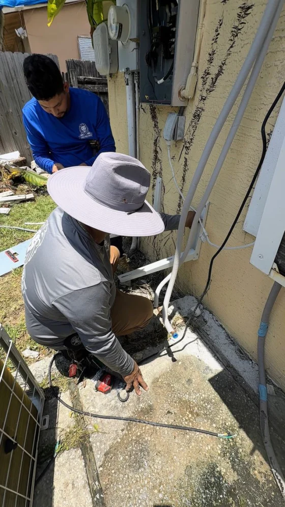 Technicians working on an exterior electrical panel