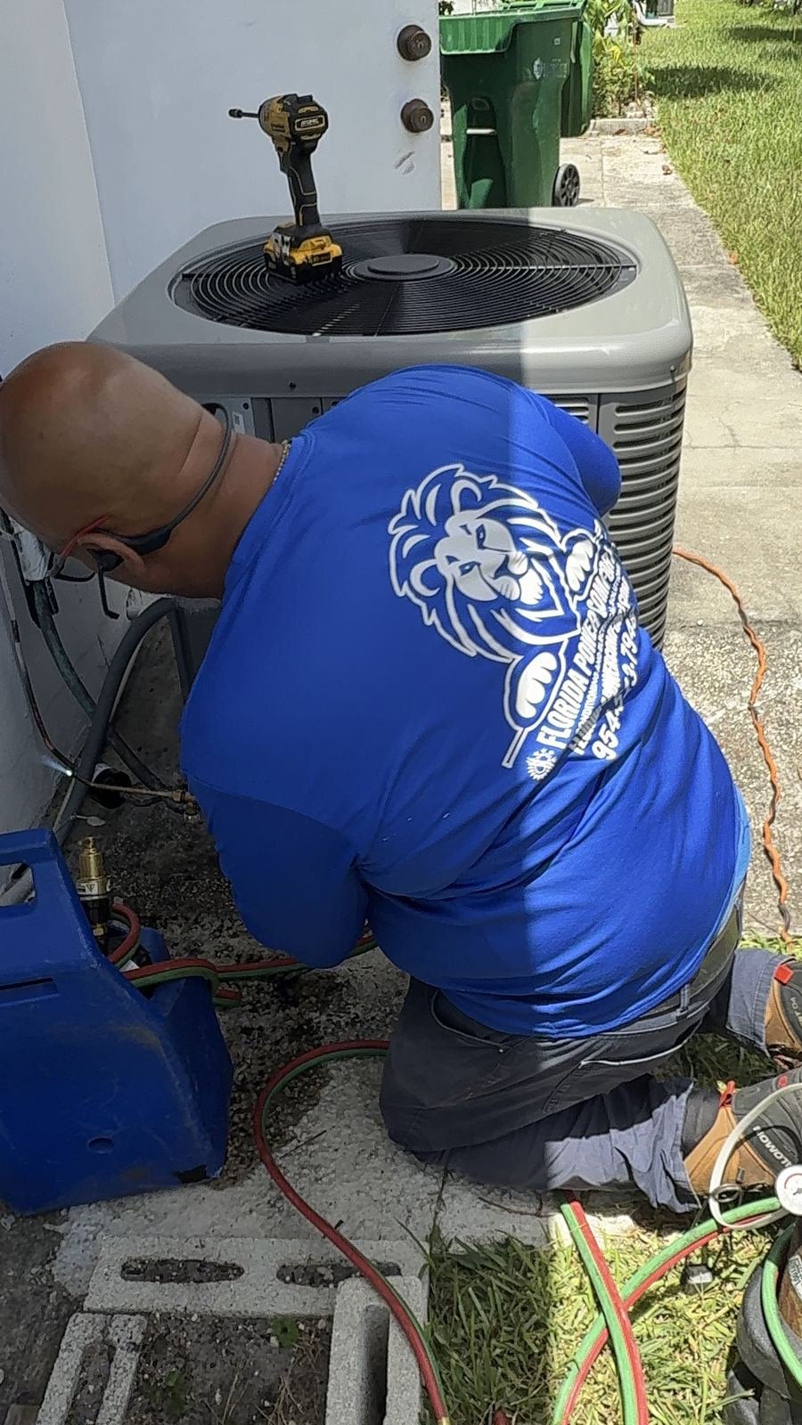 Technician brazing copper refrigerant lines on an AC condenser