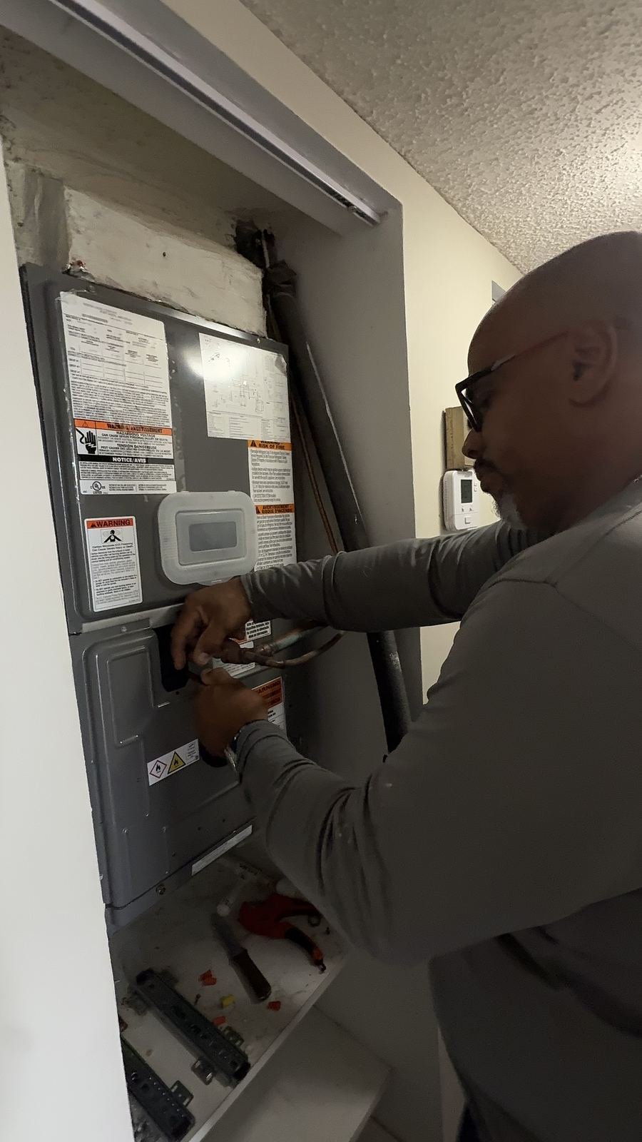 Two Florida Power Comfort technicians inspecting an electrical panel