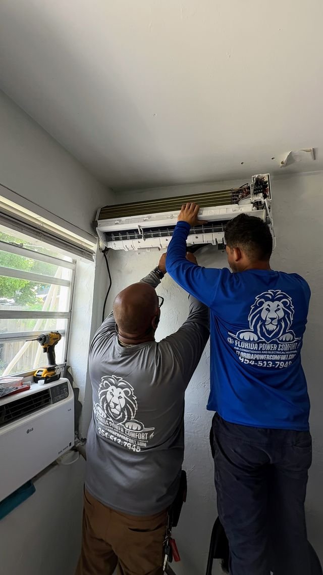 Technicians installing a wall-mount mini-split indoor unit